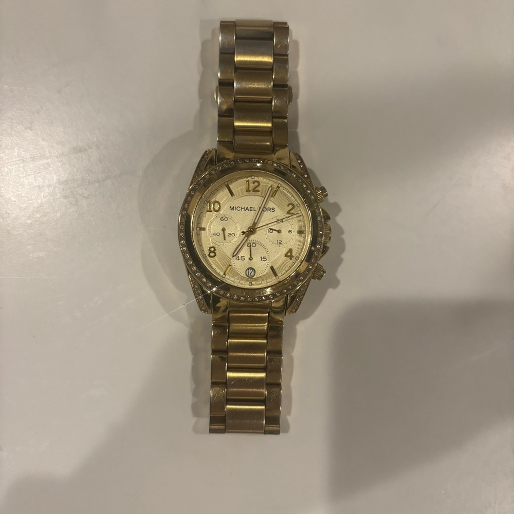 Michael Kors gold watch with faux diamonds around the face